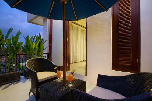a table with two chairs and a blue umbrella at The oasis retreat seminyak in Seminyak