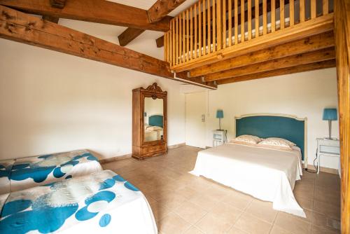 a bedroom with two beds and a mirror at Escale au Salagou in Le Bosc