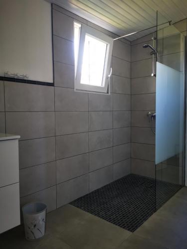 La salle de bains est pourvue d'une douche et d'une fenêtre. dans l'établissement Charmante maison de vacances avec piscine, à Gallargues-le-Montueux