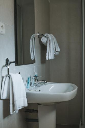 une salle de bain avec un lavabo, un miroir et des serviettes dans l'établissement Résidence Idéal-Subrini, à Porto Ota