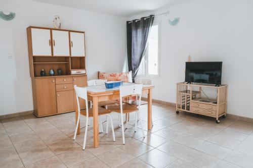 a dining room with a table and chairs and a tv at Résidence Idéal-Subrini in Porto Ota