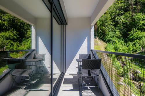 d'un balcon avec des chaises et une vue sur les arbres. dans l'établissement Liom Apartment by Quokka 360 - one-bedroom design apartment with balcony, à Gudo