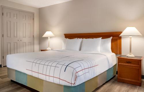 a bedroom with a large bed with two lamps at La Quinta Inn by Wyndham Columbus Airport Area in Columbus