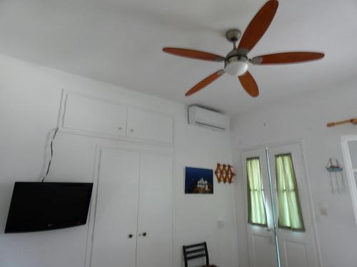 a ceiling fan in a living room with a tv at Το Κατἑ in Artemonas