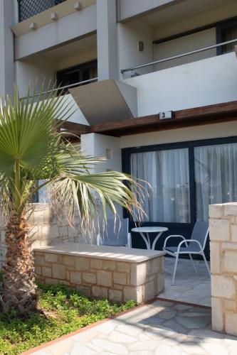 a palm tree in front of a house at Sol Marina Beach Crete in Gouves