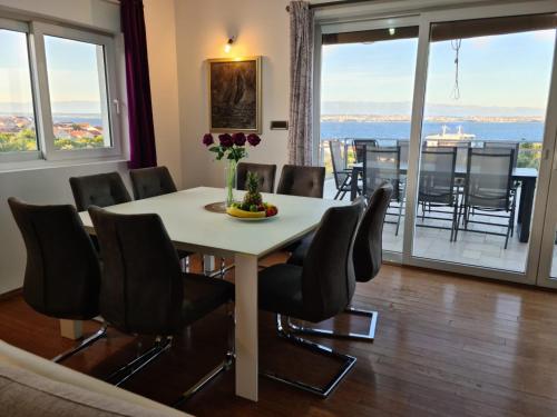 a dining room with a table and chairs with a view at Villa Vesna in Preko