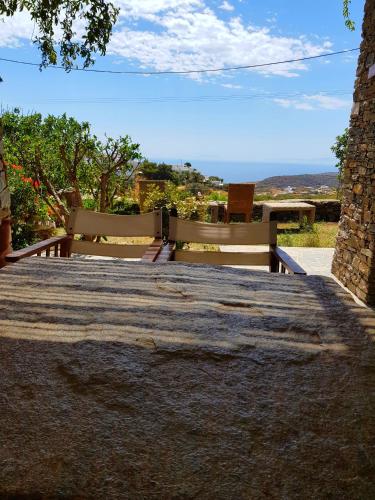 a table with two benches and a view of the ocean at Το Κατἑ in Artemonas