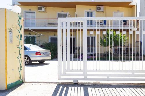 a white gate in front of a house at Mema's Tranquil Apartment in Patra in Patra