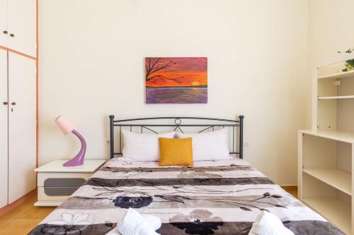 - une chambre avec un lit et une peinture murale dans l'établissement Mema's Tranquil Apartment in Patra, à Patras