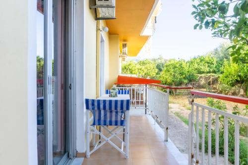 Un balcón de una casa con una silla azul en Mema's Tranquil Apartment in Patra, en Patra