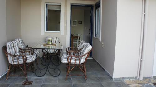un patio con mesa y sillas en un porche en EOΣ en Nikiana
