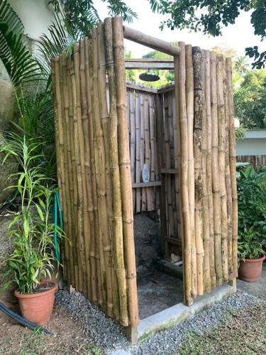 a wooden fence in front of a garden at Crystal Apartments Seychelles SeaView Upper Floor in Glacis