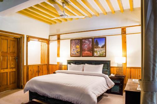a bedroom with a large bed with white sheets at Greens By Roomy, Kalam in Kalām