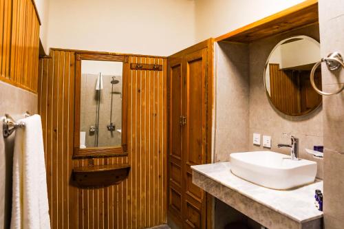 a bathroom with a sink and a shower and a mirror at Greens By Roomy, Kalam in Kalām