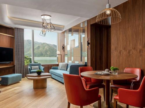 - un salon avec un canapé, une table et des chaises dans l'établissement The Silveri Hong Kong - MGallery, à Hong Kong