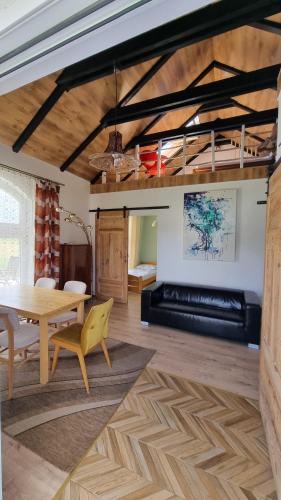 a dining room with a table and a couch at Agroturystyka u Karoliny in Sarbinowo