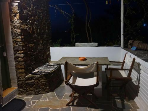 a table and chairs on a patio at night at Το Κατἑ in Artemonas