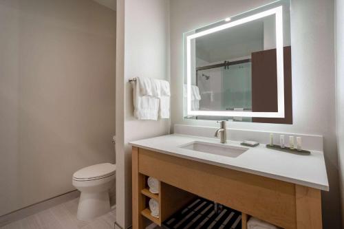 a bathroom with a sink and a toilet and a mirror at La Quinta Inn & Suites by Wyndham Pflugerville in Pflugerville