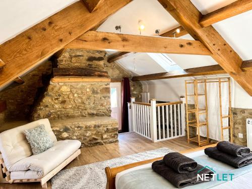 une grande pièce mansardée avec un mur en pierre dans l'établissement Hafan Hedd - Romantic Rural Retreat in Pembrokeshire, à Solva