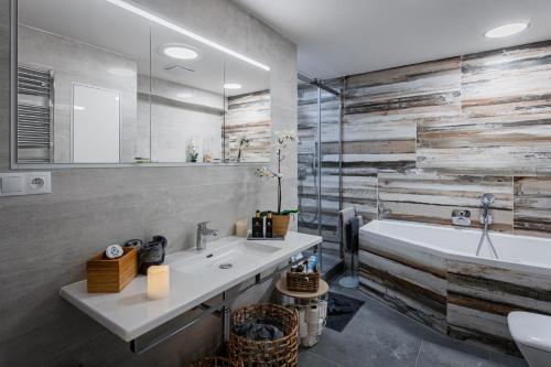 a bathroom with a sink and a bath tub at Penthouse Letňanské zahrady in Prague