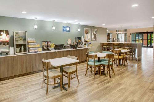 a restaurant with tables and chairs and a counter at Clarion Pointe Atlanta Airport College Park in Atlanta
