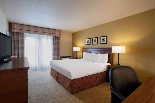 um quarto de hotel com uma cama e uma televisão em Travelodge Suites by Wyndham Regina - Eastgate Bay em Regina