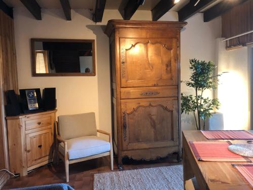 um quarto com um grande armário de madeira e uma cadeira em CHARMANT CHALET dans les monts du Forez em Le Fayt