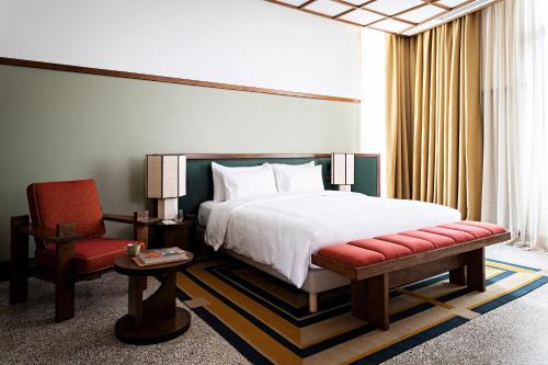 a hotel room with a bed and a chair at La Maison Palmier Abidjan, a Member of Design Hotels in Abidjan