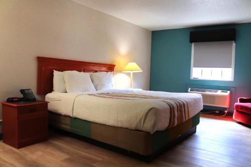 a hotel room with a bed and a window at La Quinta Inn by Wyndham Columbus Airport Area in Columbus