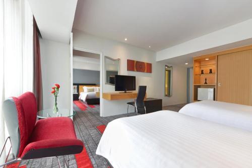 a hotel room with a large bed and a desk at BelAire Bangkok Sukhumvit in Bangkok