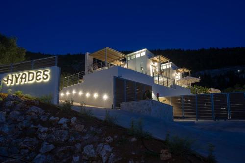 a house with lights on the side of it at night at HYADES VILLAS LEFKADA in Agios Nikitas