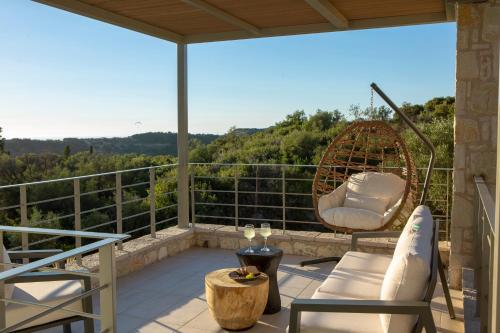 a patio with chairs and a swing on a balcony at HYADES VILLAS LEFKADA in Agios Nikitas