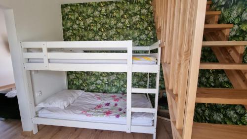 a couple of white bunk beds in a room at Agroturystyka u Karoliny in Sarbinowo