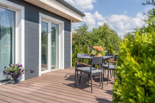 Una terraza de madera con una mesa y sillas. en Family Garden House with Free Private Parking & Playground, en Riga
