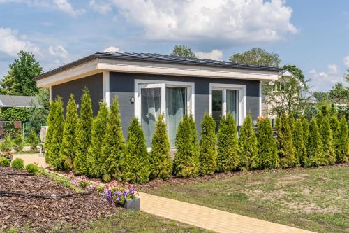 a small house with a row of trees at Family Garden House with Free Private Parking & Playground in Rīga