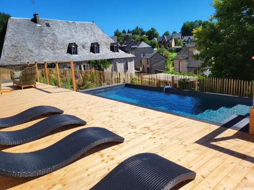 une arrière-cour avec une piscine et deux chaises longues dans l'établissement LA MAISON 1788, à Meymac