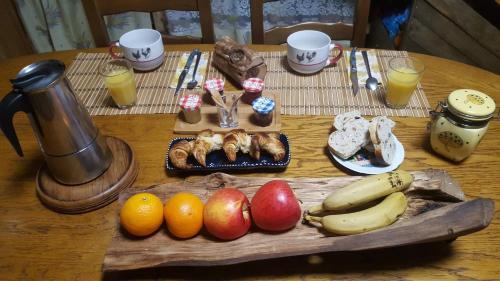 - une table en bois avec des fruits et de la nourriture dans l'établissement La Verte Salamandre, à Allanche