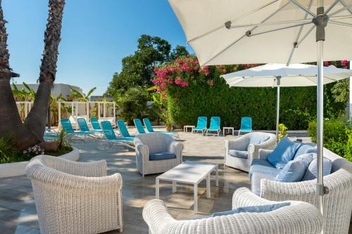 un groupe de chaises, de tables et d'un parasol dans l'établissement Hotel Vibra Marco Polo II - Adults only, à Sant Antoni de Portmany