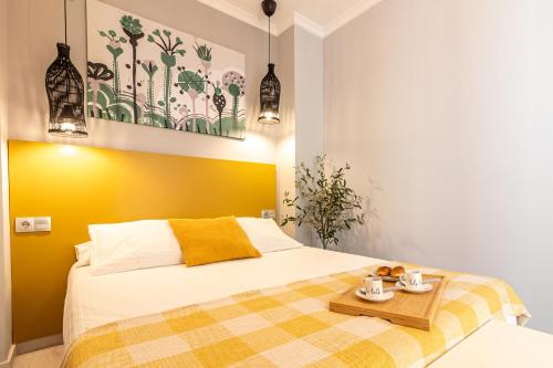 sypialnia z łóżkiem z żółtym akcentem w obiekcie Malaga Center Flat - SoHo Center Apartments w Maladze