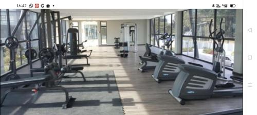 een fitnessruimte met rijen loopbanden en crosstrainers bij Hyve Soho Suite - Netflix in Cyberjaya