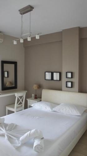 a bedroom with a white bed and a table and a chair at EOΣ in Nikiana