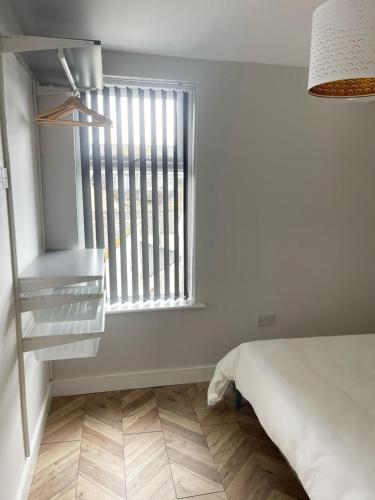 a bedroom with a window and a bed and a floor at Smith Stayz Apartments in Blackpool