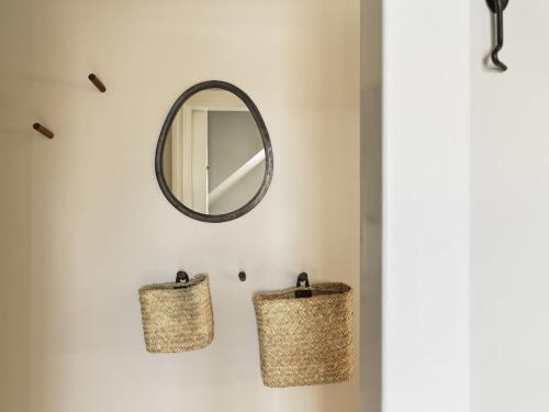 a bathroom with two baskets and a mirror at 46heima Boutique Apartments in Reykjavík