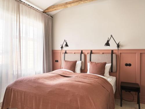 a bedroom with a large bed with pink sheets at 46heima Boutique Apartments in Reykjavík