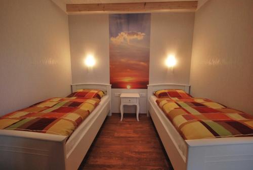 two beds in a room with a painting on the wall at Ferienobjekte Claus, 35633 in Uplengen