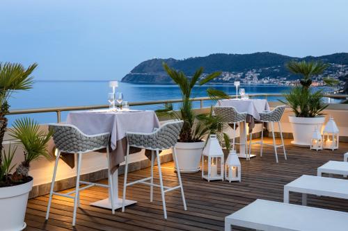 a restaurant with tables and chairs on a balcony at Grand Hotel Spiaggia in Alassio