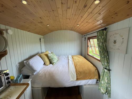 a bedroom in a tiny house with a bed in it at Puddle Duck Shepherd Hut in Launceston