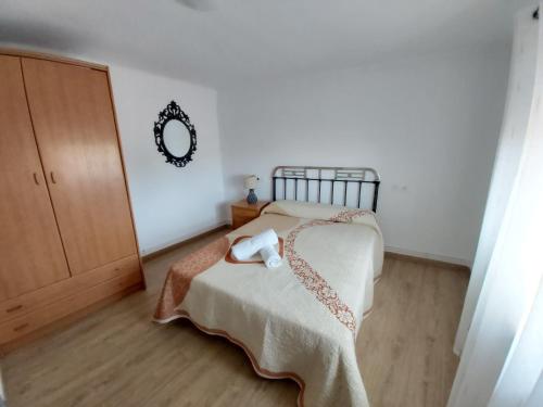 ein Schlafzimmer mit einem Bett und einem Spiegel an der Wand in der Unterkunft CASA DEL ABUELO Viana de Duero Soria in Viana de Duero