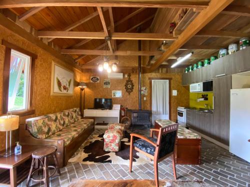 a living room with a couch and a table at Chalé Estilo Alemão - Centro de Canela in Canela
