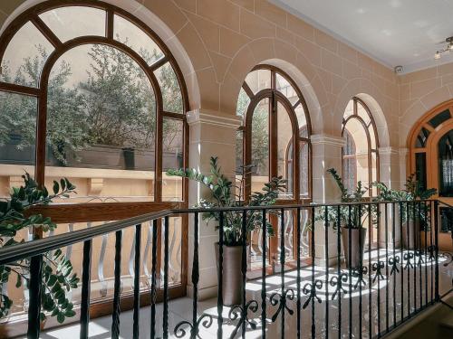 a lobby with arched windows and potted plants at IL-Gardjola Bed and Breakfast in Għarb
